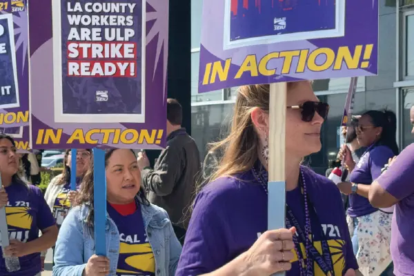 Union members holding picket signs march outside the Metro North DCFS building in downtown LA.