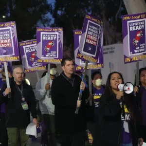 Picture of member marching with signs at early-morning practice picket.