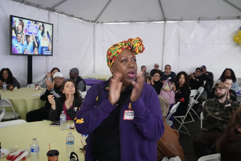 LA County union members seated at tables applaud.