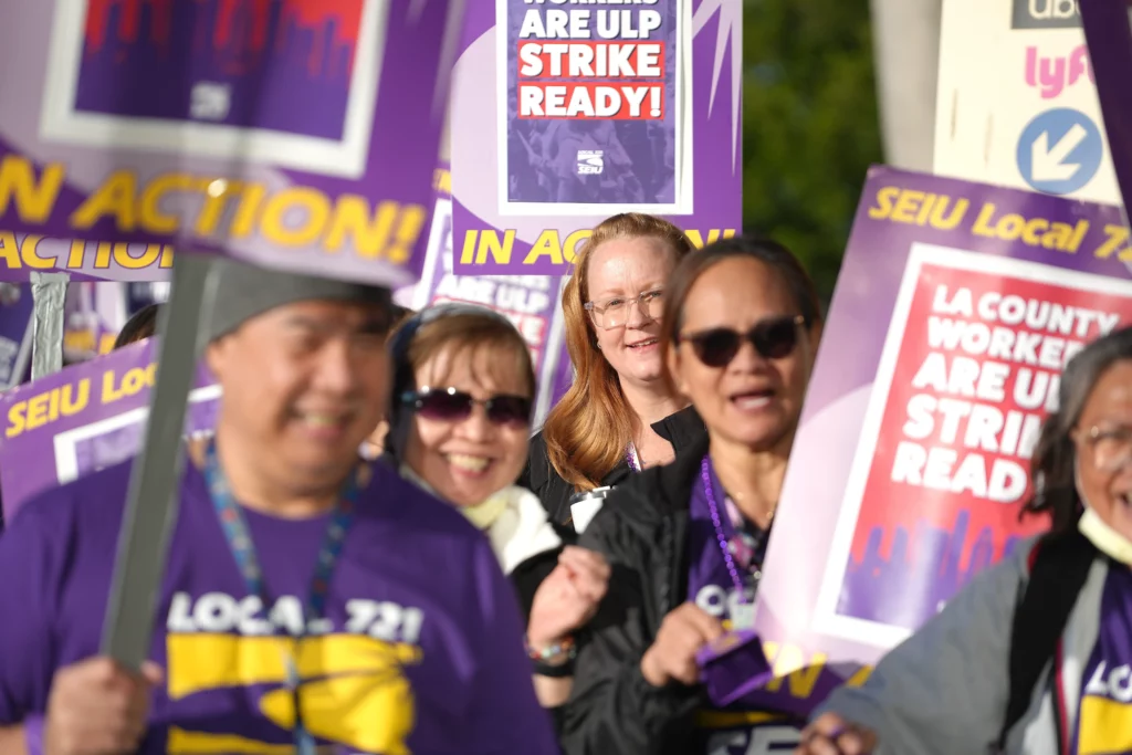 SEIU 721 members from the Olive View-UCLA Medical Center in Sylmar hold picket signs and smile.