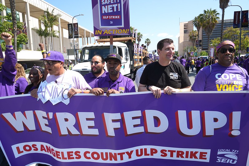 LA County leadership marches down Grand Ave. holding a banner that says: "WE'RE FED UP! LOS ANGELES COUNTY ULP STRIKE"