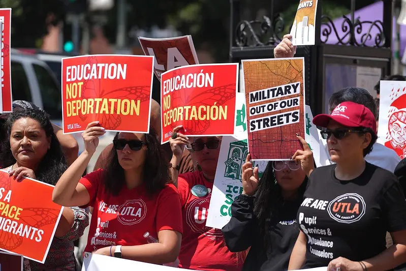 UTLA members hold signs saying "Education Not Deportation" and "Military Out of Our Streets".