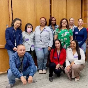 Crowd of LA Superior Court employees gather for a group photo. Three members are kneeling, and seven other members are standing behind them.
